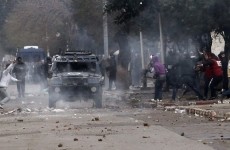Protesters run as police fire tear gas during clashes in Baraki, near Algiers