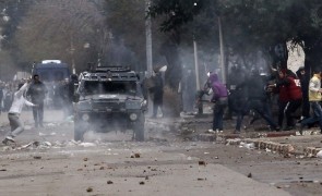 Protesters run as police fire tear gas during clashes in Baraki, near Algiers